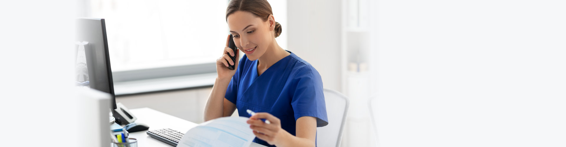 happy smiling female with computer and clipboard calling on phone